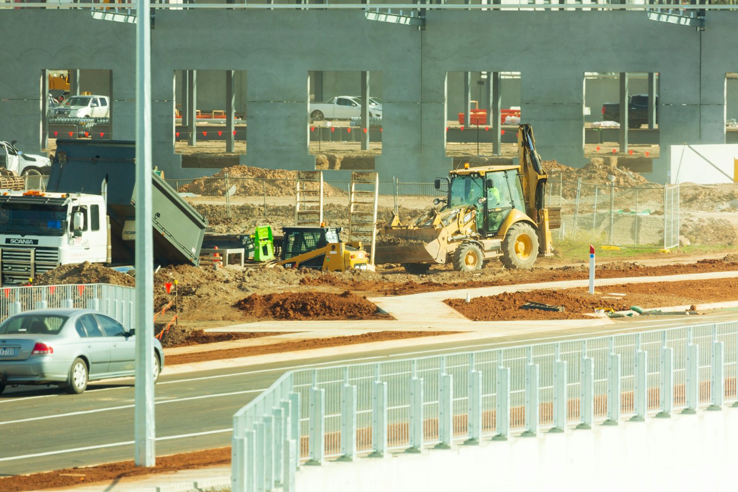 Construction site with heavy machinery and a new building.